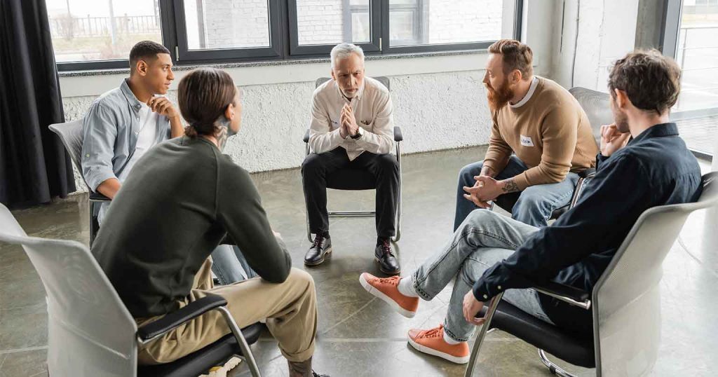 men in outpatient rehab treatment discussing therapy