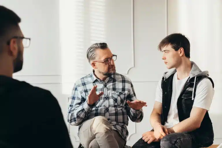 Therapist and client reviewing 12-step worksheets together during a clinical treatment session